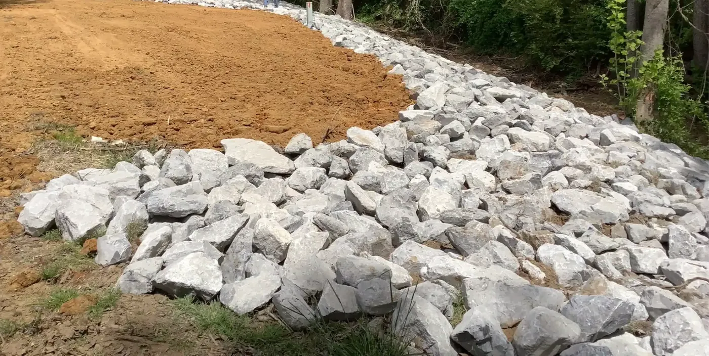 Riprap apron protecting the edge of a graded and strawed pad